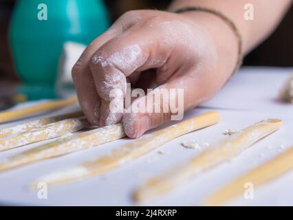 Gros plan des mains d'une fille qui ramassant des outils pour travailler avec l'argile. Artisanat pour enfants Banque D'Images