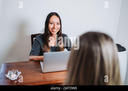 Jeune thérapeute latin prenant des données d'un patient méconnaissable avant une réunion médicale. Services de conseil en santé. Banque D'Images