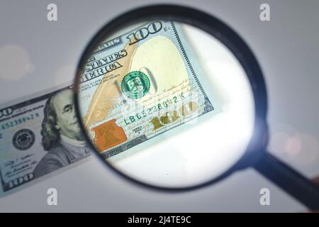 Zoom sur l'argent. Loupe - 100 dollars US. Concept sur le thème de la vérification de l'authenticité de l'argent Banque D'Images