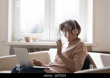 Femme mature porter un casque Profitez de la communication utilisez un ordinateur portable et la vidéoconférence Banque D'Images