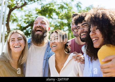 Jeune groupe d'amis divers s'amusant dehors dans une journée ensoleillée Banque D'Images