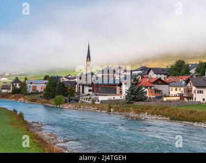 River Inn et village de Zuoz, commune de la région de Maloja dans le canton suisse de Graubunden. Ambiance féogeuse d'automne idyllique, Banque D'Images