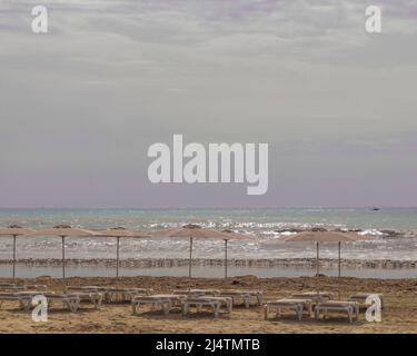 Parasols et chaises longues sur la plage de la mer Méditerranée Banque D'Images