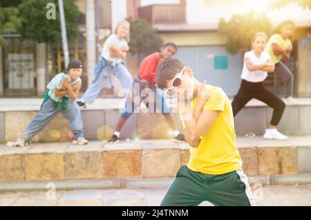 Danseuse de hip hop Tween boy qui se interprète avec un groupe dans la rue de la ville Banque D'Images