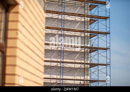 Échafaudage, échafaudage mobile en métal, fond bleu ciel. Un bâtiment moderne est en construction, un échafaudage en métal. Banque D'Images