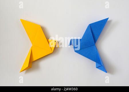Deux colombes de la paix comme la couleur du drapeau ukrainien. Concept minimal de crise politique nationale du monde de l'aide et du soutien. Jouet origami. Banque D'Images
