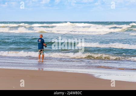 Un pêcheur sur 75 Mile Beach sur la côte est de l'île Fraser. Queensland, Australie. Banque D'Images