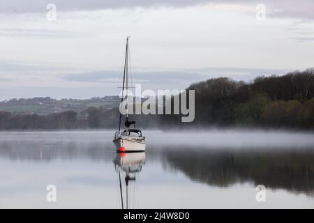 Drake's Pool, Crosshaven, Cork, Irlande. 18th avril 2022. Lors d'un calme lundi de vacances en bord de mer, le bateau à voile Tantine se trouve encore tandis que la brume s'élève de la rivière Owenabue, dans la piscine de Drake, à l'extérieur de Crosshaven, Co. Cork, en Irlande. - Crédit; David Creedon / Alamy Live News Banque D'Images