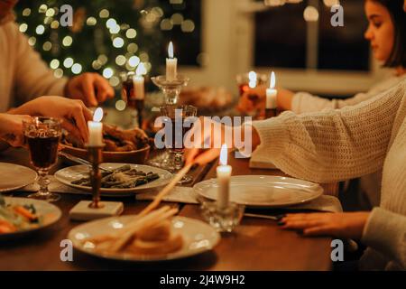 Une grande famille heureuse avec de nombreux enfants célébrant Noël ou le nouvel an ensemble dans une maison chaleureuse et confortable, se rassemblant autour de table de vacances festives avec de Banque D'Images