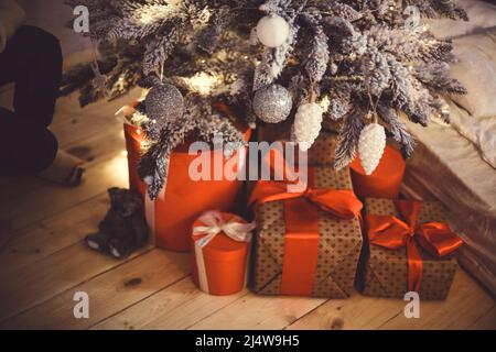 Sapin de noël aux couleurs vives avec beaucoup de cadeaux sur le plancher de bois près de la fenêtre avec espace de copie. Concept Noël et bonne année Banque D'Images