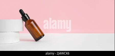 Flacons à cosmétiques compte-gouttes en verre ambré, podium blanc. Soin naturel de la peau SPA beauté conception de produit. Pipette à huile organique, fond rose. Vue avant. 3D Banque D'Images