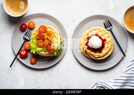 Petit déjeuner complet avec gaufres et café, vue de dessus. Différentes garnitures pour les sandwichs - crème glacée et légumes. Banque D'Images