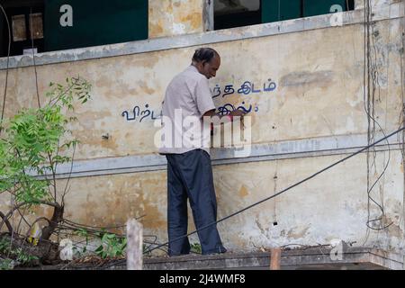 Homme peint un panneau non destiné à la vente sur la façade d'une maison en ruine à Trichy, Tamil Nadu, Inde Banque D'Images