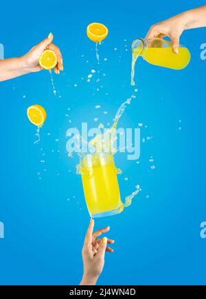 Femme soutien main Fly verre de délicieux cocktail avec citron et glace avec splash, ingrédients tombant à glass. Les mains des femmes versent le jus de bott Banque D'Images