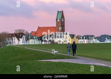 Cuxhaven, Allemagne - 02.25.2022: Couple marchant sur la passerelle en haut de la barrière d'inondation dans le port de Cuxhaven, très tôt le matin d'hiver. Ludowin du ciel Banque D'Images