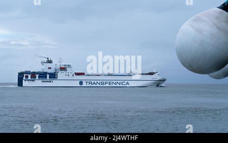 Cuxhaven, Allemagne - 02.25.2022: Transfennica conteneur cargo naviguant dans la mer depuis le port de Cuxhaven lors d'une journée d'hiver gris nuageux. Alimentation c Banque D'Images