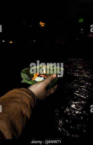 défotee tenant aarti pot de fleurs pour la prière du soir de la rivière ganges la nuit Banque D'Images