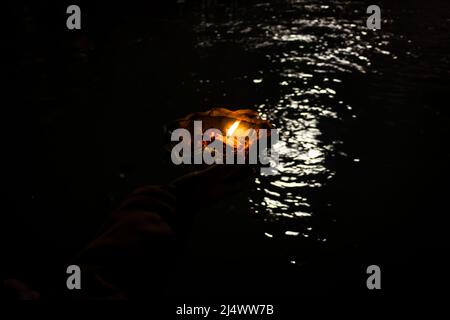 défotee tenant aarti pot de fleurs pour la prière du soir de la rivière ganges la nuit Banque D'Images