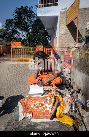 Les saints indiens écrivant sur papier au jour à partir de l'image d'angle plat est pris au temple bhutnath rishikesh uttrakhhand inde le 15 2022 mars. Banque D'Images