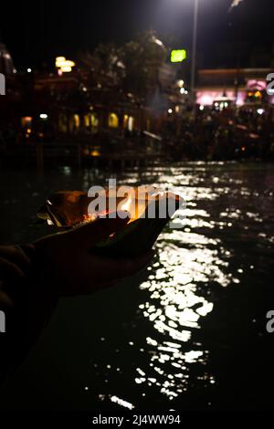 défotee tenant aarti pot de fleurs pour la prière du soir de la rivière ganges la nuit Banque D'Images