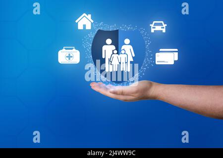 Main Womand montrant le bouclier bleu de l'assurance vie familiale et de la police. Icônes de voiture, famille, vie et assurance maladie. Banque D'Images