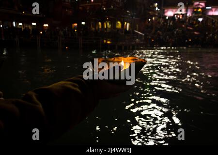 défotee tenant aarti pot de fleurs pour la prière du soir de la rivière ganges la nuit Banque D'Images