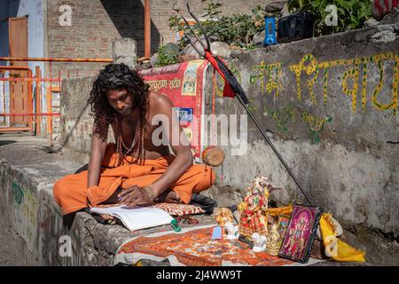 Les saints indiens écrivant sur papier au jour à partir de l'image d'angle plat est pris au temple bhutnath rishikesh uttrakhhand inde le 15 2022 mars. Banque D'Images