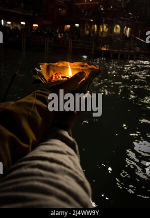 défotee tenant aarti pot de fleurs pour la prière du soir de la rivière ganges la nuit Banque D'Images