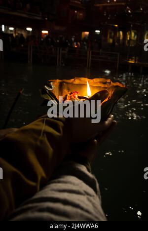 défotee tenant aarti pot de fleurs pour la prière du soir de la rivière ganges la nuit Banque D'Images