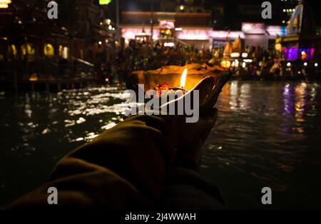 défotee tenant aarti pot de fleurs pour la prière du soir de la rivière ganges la nuit Banque D'Images