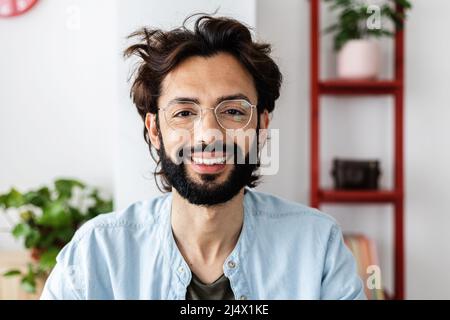 Un jeune entrepreneur qui a réussi à sourire à la caméra lors d'un appel vidéo Banque D'Images