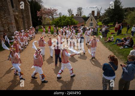 Lundi de Pâques Morris Dancing Thaxted Essex, Royaume-Uni. 18th avril 2022. À la fin du printemps, par temps chaud, les danseuses de Morris Thaxted en rouge et blanc, en visitant les danseurs de Dyke Morris en marron et en blanc du sud du Cambridgshire, effectuent des danses traditionnelles de dMorris dans le triage de l'église de Thaxted avec les maisons d'alms Thaxted et le moulin de John Webb en arrière-plan. Crédit : BRIAN HARRIS/Alay Live News Banque D'Images