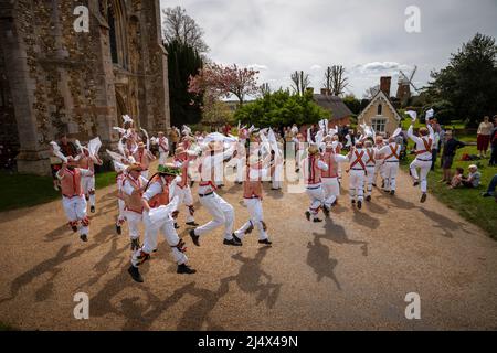Lundi de Pâques Morris Dancing Thaxted Essex, Royaume-Uni. 18th avril 2022. À la fin du printemps, par temps chaud, les danseuses de Morris Thaxted en rouge et blanc, en visitant les danseurs de Dyke Morris en marron et en blanc du sud du Cambridgshire, effectuent des danses traditionnelles de dMorris dans le triage de l'église de Thaxted avec les maisons d'alms Thaxted et le moulin de John Webb en arrière-plan. Crédit : BRIAN HARRIS/Alay Live News Banque D'Images