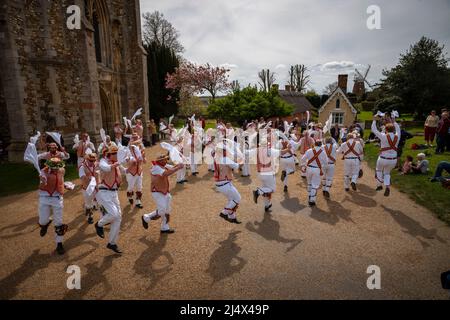 Lundi de Pâques Morris Dancing Thaxted Essex, Royaume-Uni. 18th avril 2022. À la fin du printemps, par temps chaud, les danseuses de Morris Thaxted en rouge et blanc, en visitant les danseurs de Dyke Morris en marron et en blanc du sud du Cambridgshire, effectuent des danses traditionnelles de dMorris dans le triage de l'église de Thaxted avec les maisons d'alms Thaxted et le moulin de John Webb en arrière-plan. Crédit : BRIAN HARRIS/Alay Live News Banque D'Images