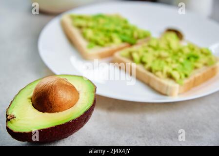 Toasts avec avocat sur plaque blanche, concept de nourriture saine et de diète, produit biologique Banque D'Images