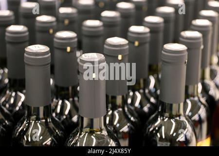 Bouteilles de vin rouge en rangée, mise au point sélective. Magasin de spiritueux, concept de production de vin Banque D'Images