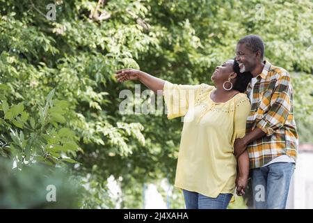 bonne femme afro-américaine senior pointant de la main près de son mari dans le parc Banque D'Images