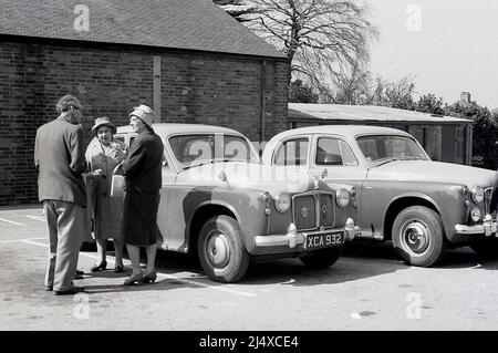 1950s, historique, personnes âgées officiellement vêtues, stand par deux automobiles Rover de l'époque ayant discuté dans un parking, Angleterre, Royaume-Uni, Banque D'Images