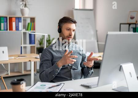 Concept de visioconférence. Portrait d'un responsable d'entreprise mature ayant un appel Web assis sur son lieu de travail au bureau Banque D'Images