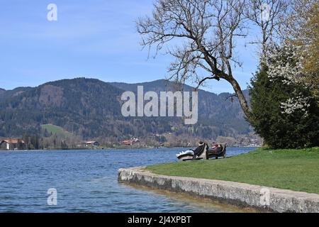 Pâques 2022 sur le lac Tegernsee. Vue de Bad Wiessee sur le lac Tegernsee le 18th avril 2022, les touristes apprécient le merveilleux temps printanier sur des chaises longues en bois malgré un vent d'est froid. Printemps, soleil, paysage, montagnes, alpes, montagnes.lac, rivage. Banque D'Images