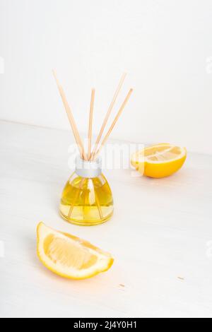 Bouteille en verre de diffuseur d'arôme et de tranches de citron sur fond blanc. Mise au point sélective Banque D'Images