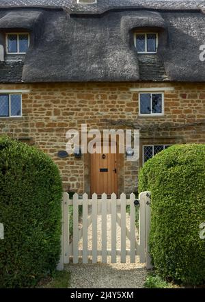 Cottage de chaume avec porte blanche Great TEW Oxfordshire Banque D'Images