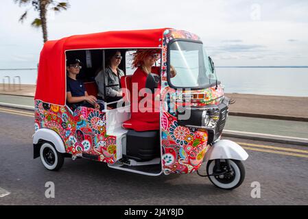 Southend on Sea, Essex, Royaume-Uni. 18th avril 2022. Depuis de nombreuses années, le 'Soutihend Shakedown' est un lundi de Pâques qui se réunit régulièrement sur le front de mer, attirant des milliers de motocyclistes pour leur premier grand tour de l'année, d'où 'Shakedown'. De retour après une pause pour COVID l'événement a apprécié le bon temps du week-end de Pâques. Femme conduisant un Tuk Tuk ou un pousse-pousse automatique, passant le long du front de mer Banque D'Images