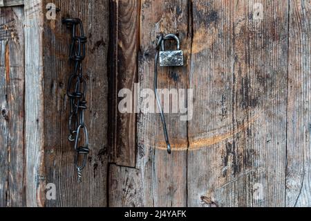 Ancienne serrure et chaîne sur une ancienne porte. Cadenas sur la grange. Anciennes portes. Banque D'Images