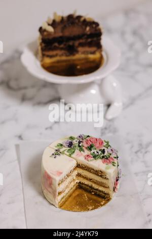 Tranche de gâteau tiramisu bento. Présentation du gâteau dans la section. Dessert sucré pour une personne. Petit gâteau d'anniversaire. Arrière-plan d'autres gâteaux bento Banque D'Images