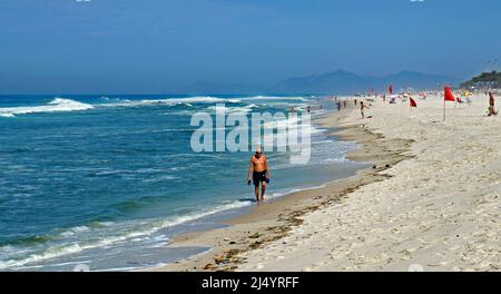 RIO DE JANEIRO, BRÉSIL - 25 MARS 2017 : un vieil homme marchant sur la plage de Barra da Tijuca. Banque D'Images