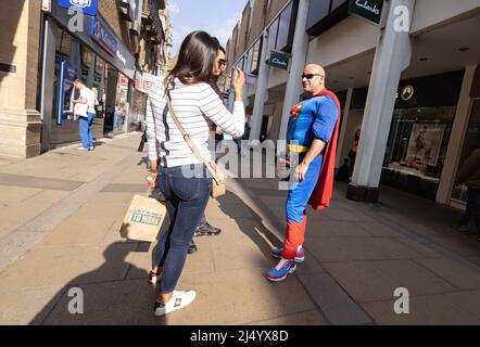 Homme portant le costume de Superman parlant à des gens, Cambridge Royaume-Uni; photographie de rue candide Royaume-Uni. Anglais excentrique. Banque D'Images