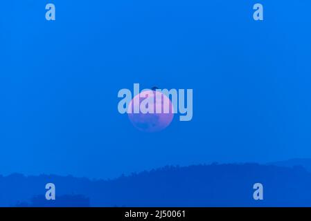 paysage de lune rose dans la lune se lève de derrière les montagnes Banque D'Images