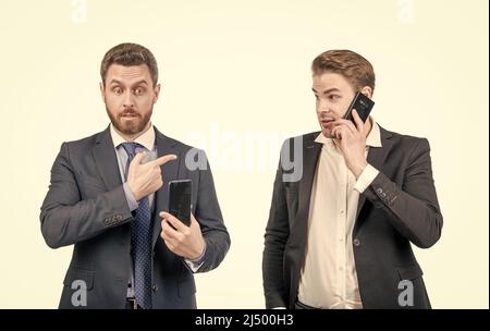 des hommes d'affaires étonnés d'un gars qui pointe du doigt sur un homme qui parle au téléphone, sur internet. Banque D'Images