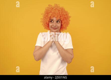 rêveuse femme libre dans la perruque clown maurichement pour la fête, rêver. Banque D'Images